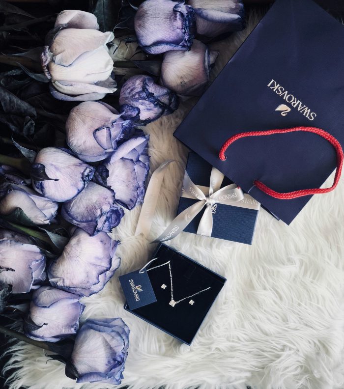 Swarovski jewellery surrounded by dark blue/purple flowers.