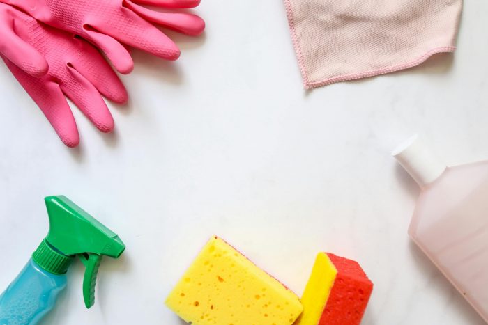 Various cleaning equipment including sponges, spray bottles, and gloves.